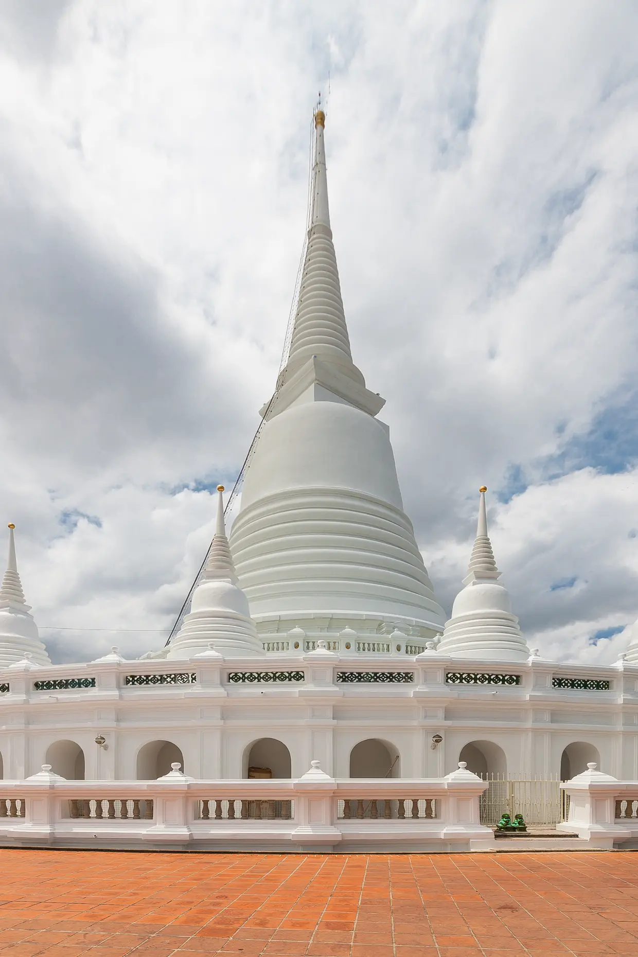 The white chedi of Wat Prayoon against a storm sky